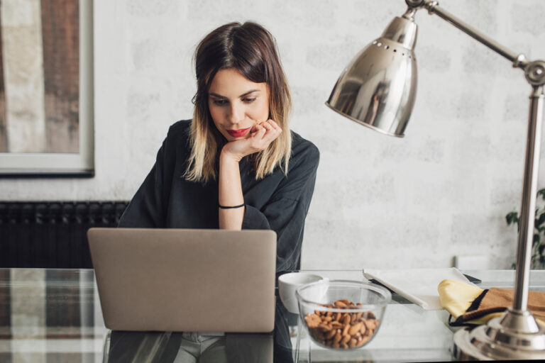 woman looking at her computer doing bookkeeping