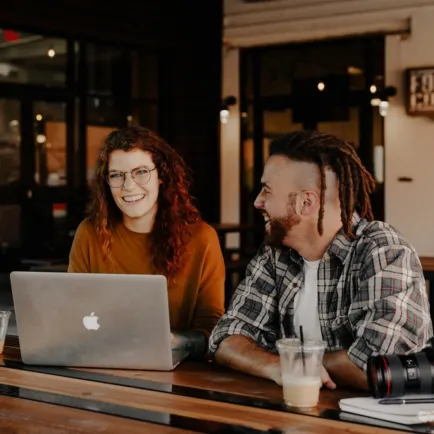 Man and woman working at a coffee shop and laughing