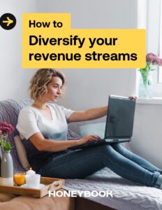Woman sits on the couch using a laptop on the cover of the How to Diversify your revenue streams guide.
