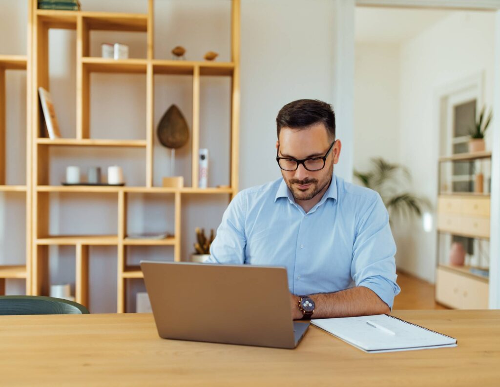 man answering pricing questions on his laptop