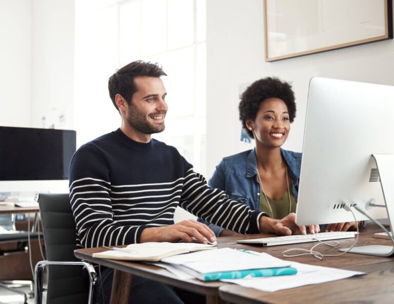 Man and woman at computer learning how to create a workflow