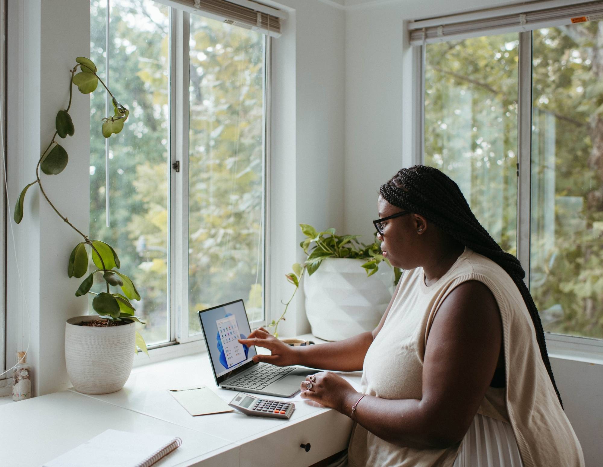 Black woman uses touch screen tablet to organize clients and sell services.