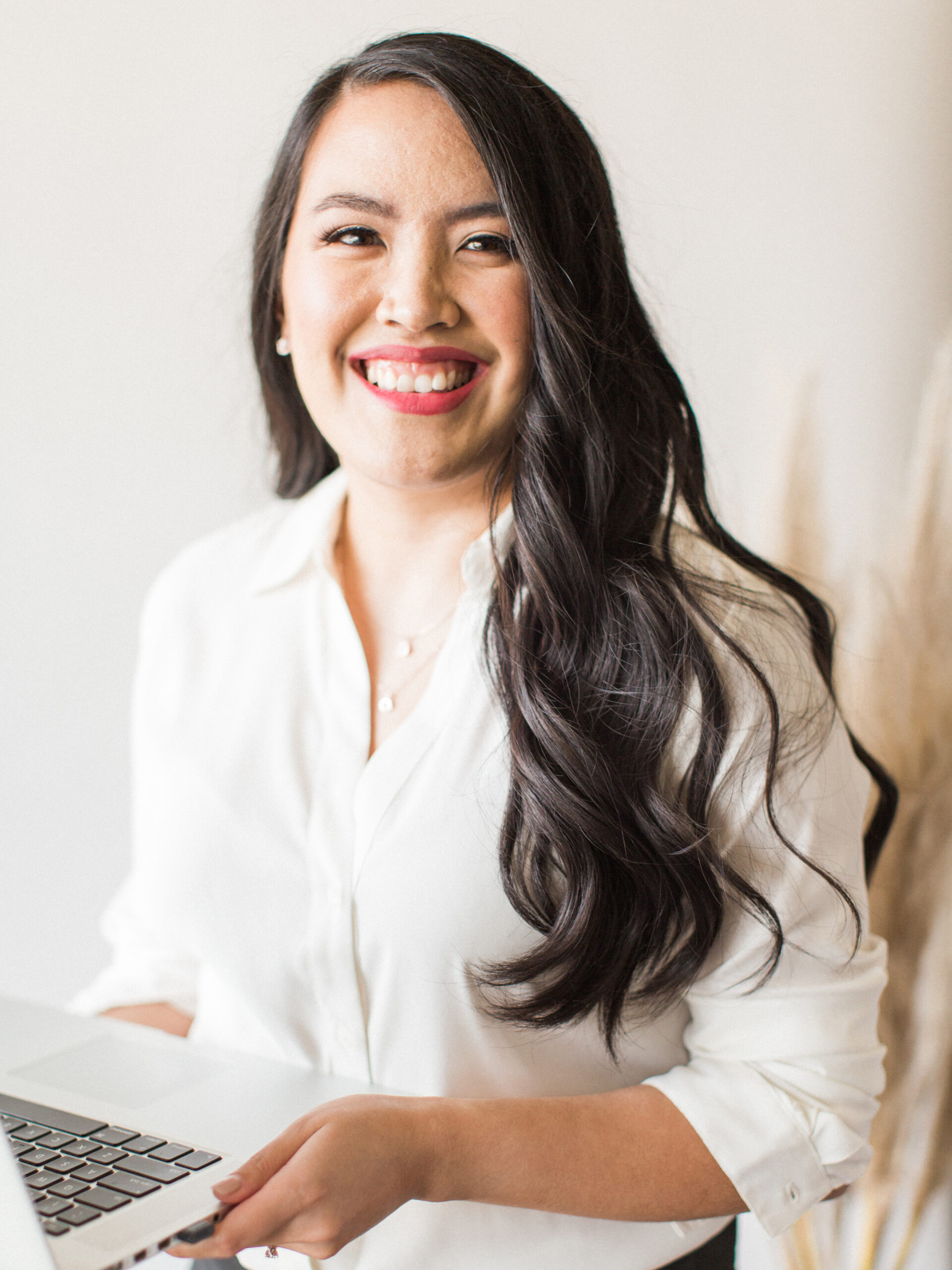 Jackie Sunga holds a computer. She is a conversion copywriter.