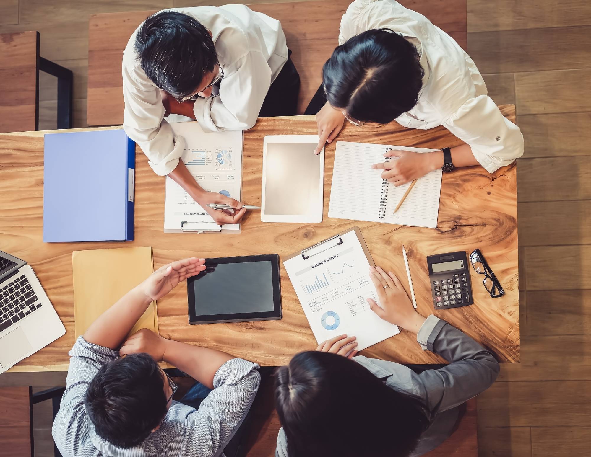 Group of workers at a table below mapping their clientflow with various documents