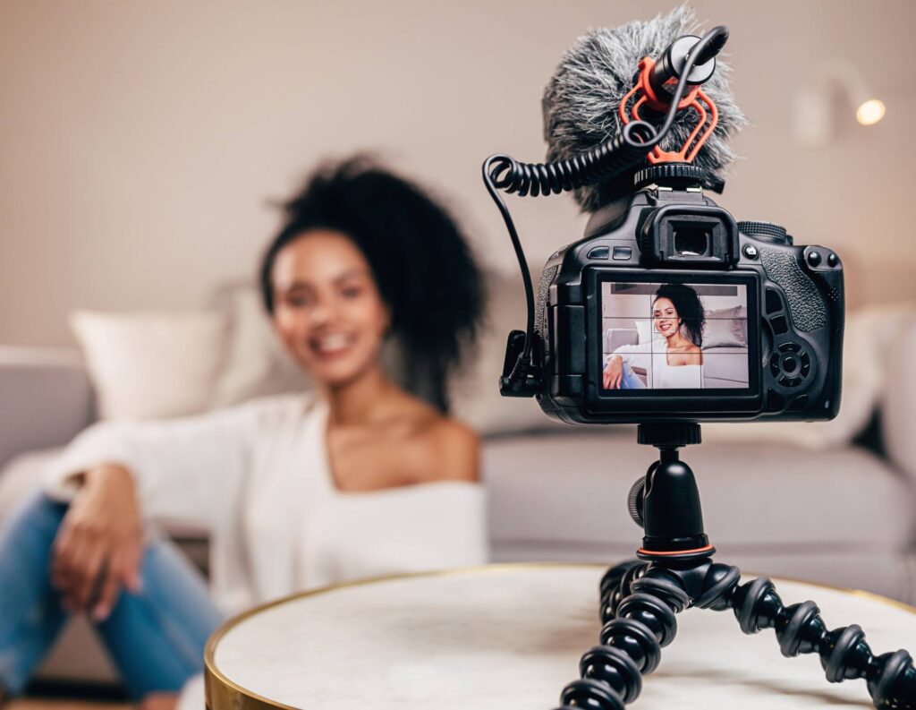 Woman filming a sales video behind a camera