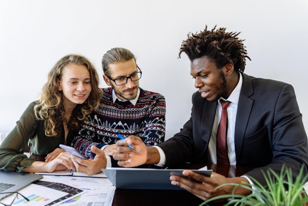 Three people reviewing sales email templates