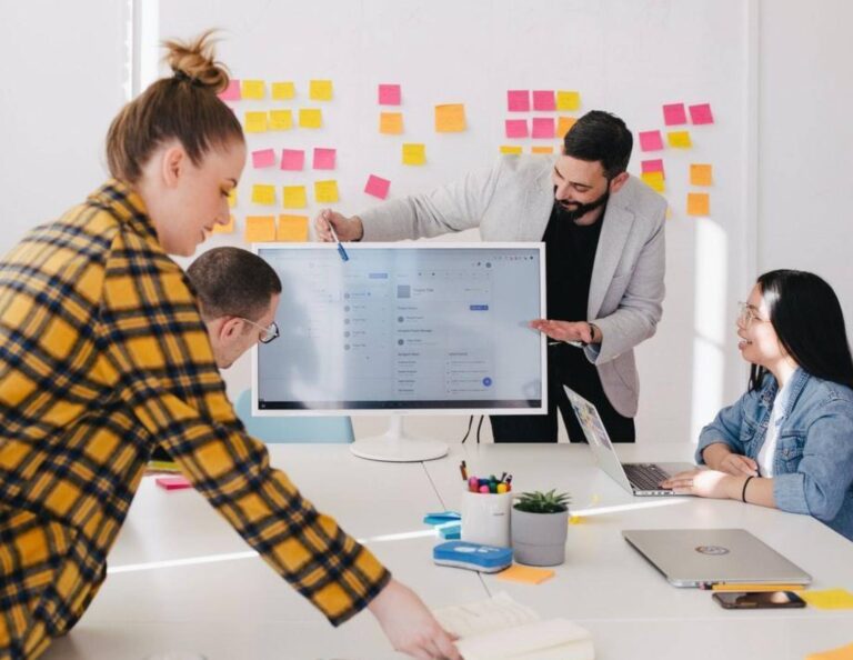 Four employees at a workshop working on a business pitch