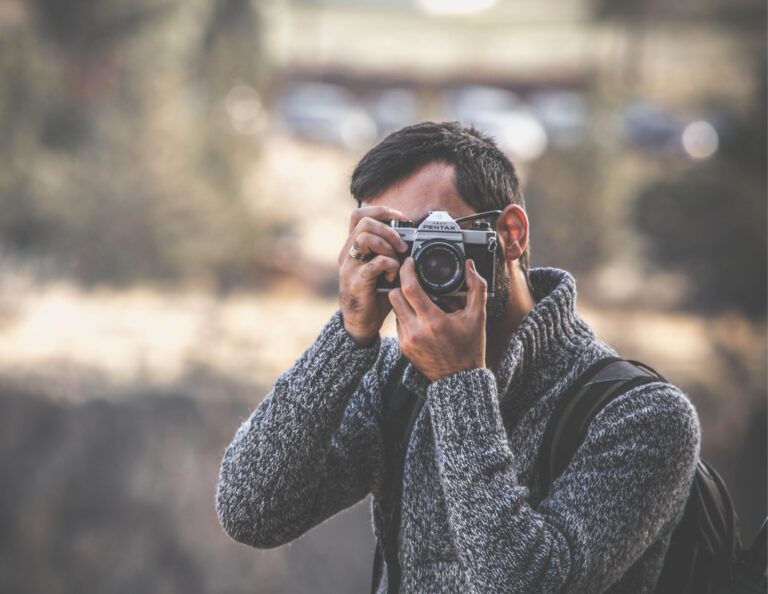 Male photographer behind a film camera