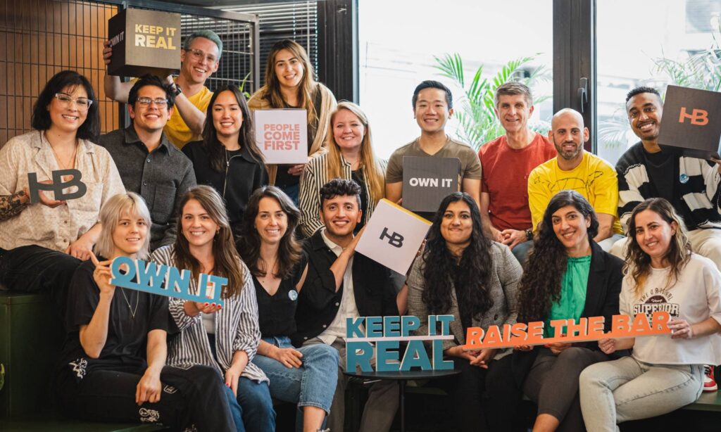 HoneyBook employees holding up core values signs