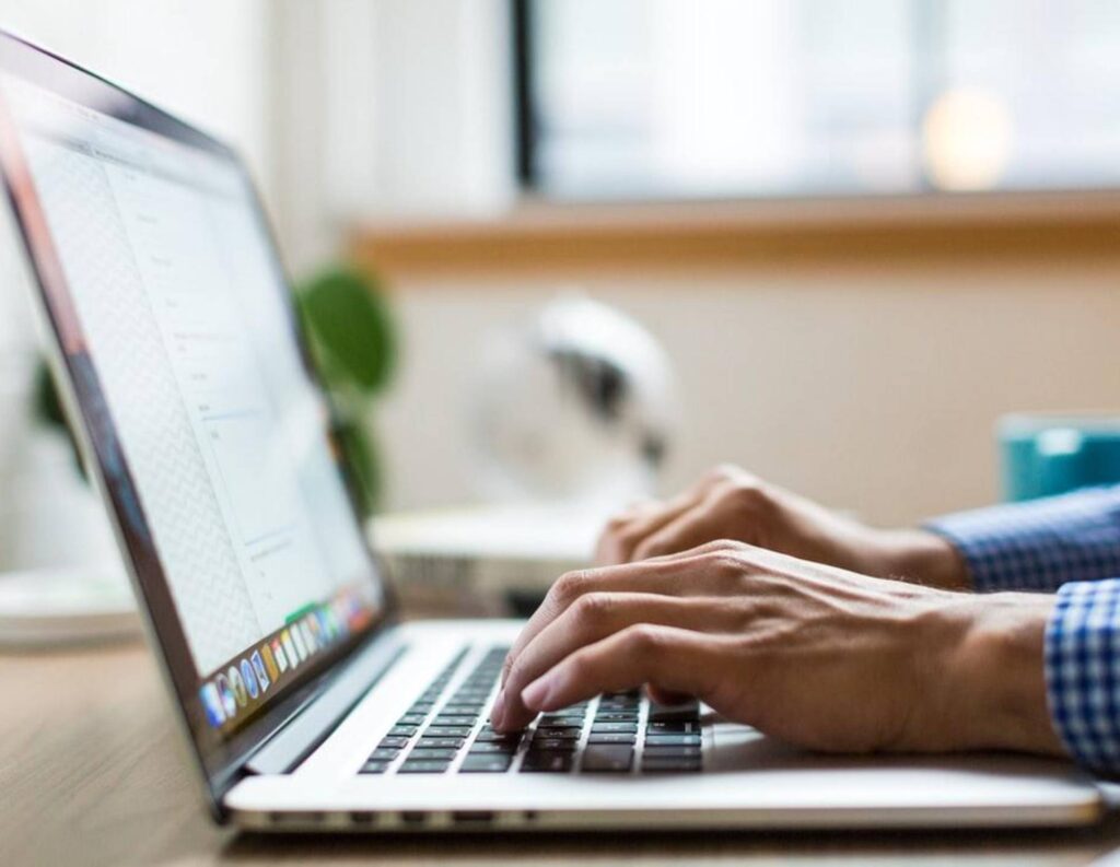 Person writing a business proposal on a laptop