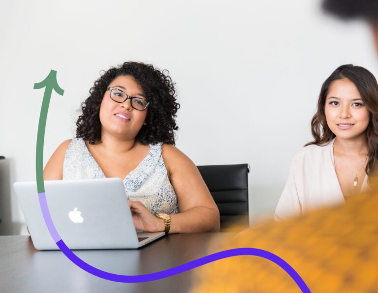 Two women discuss business at a table.