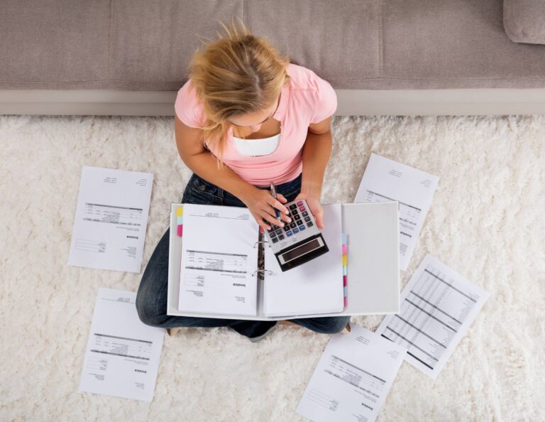 Woman sitting on the floor creating invoices