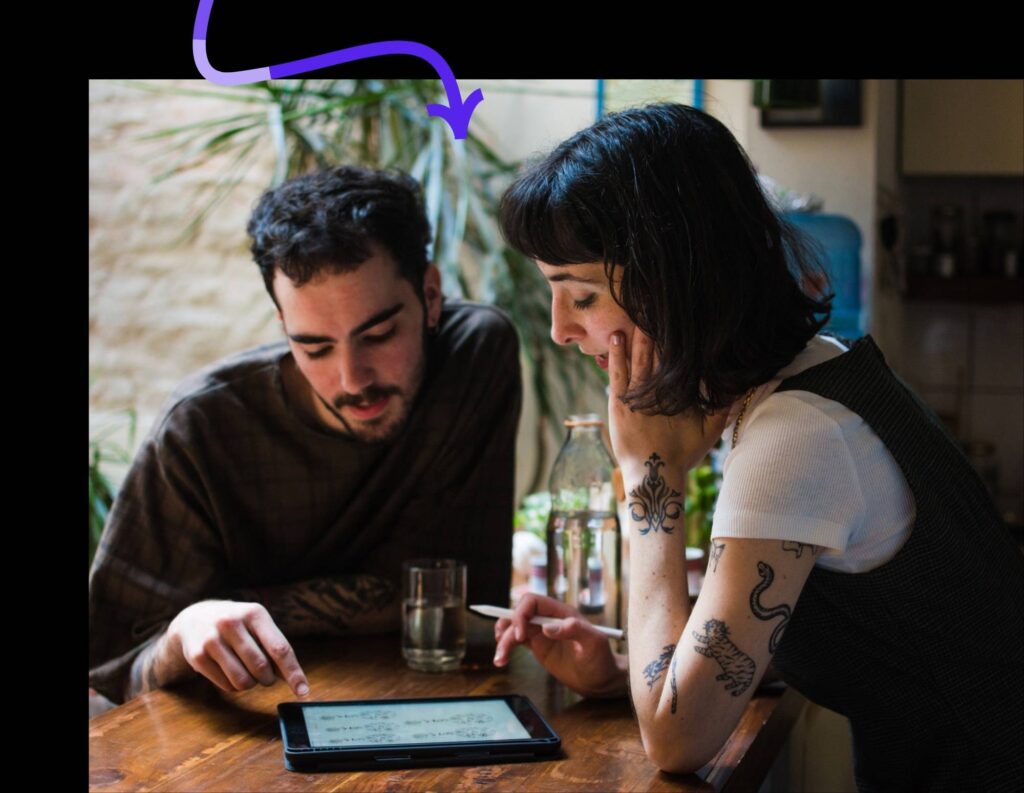 Woman business owner and employee chatting and looking at a tablet