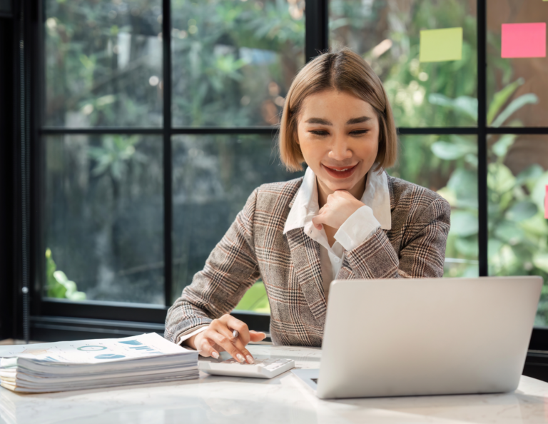 Woman sits at a desk working on her computer