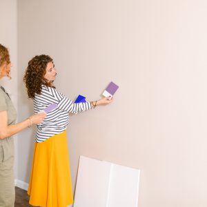 Side view holding very peri palette by female professional home designers selecting accent wall purple color for new decoration project