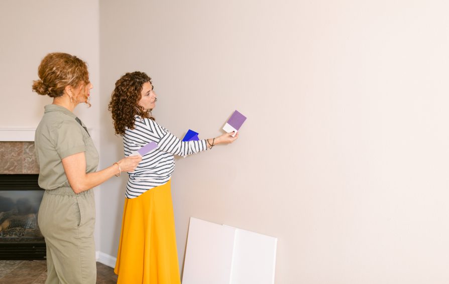 Side view holding very peri palette by female professional home designers selecting accent wall purple color for new decoration project