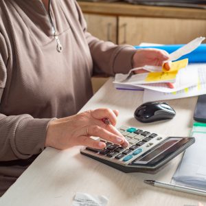 Accountant counts on a calculator and looks at receipts at his desk in the office