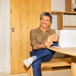Middle-aged man sitting at home, looking at someone and smiling