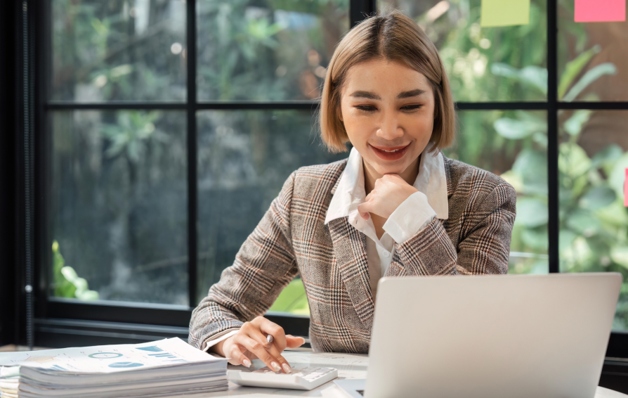 Woman sits at a desk working on her computer