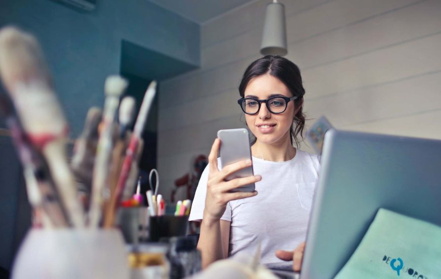 Woman stares at iPhone while working with a happy client.