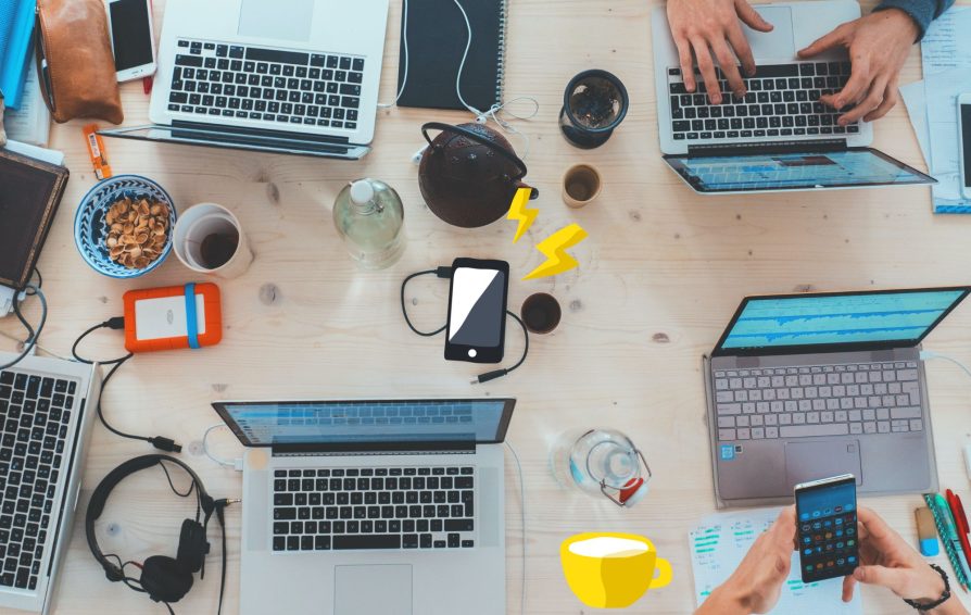 Friends gather around a table with their tech devices.