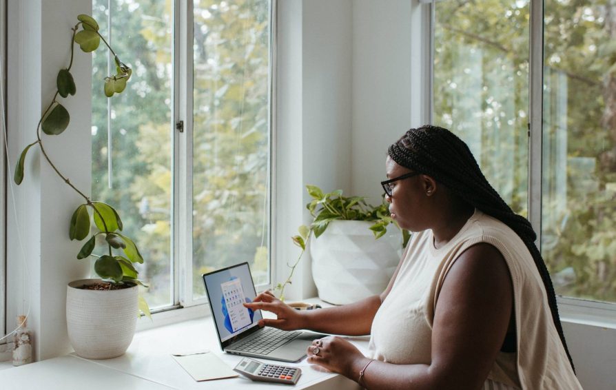 Black woman uses touch screen tablet to organize clients and sell services.