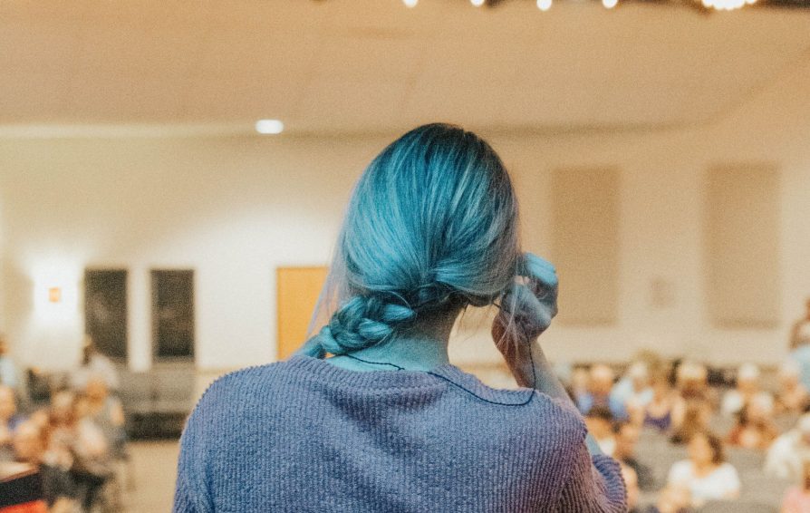 Woman speaks to crowd in an auditorium.