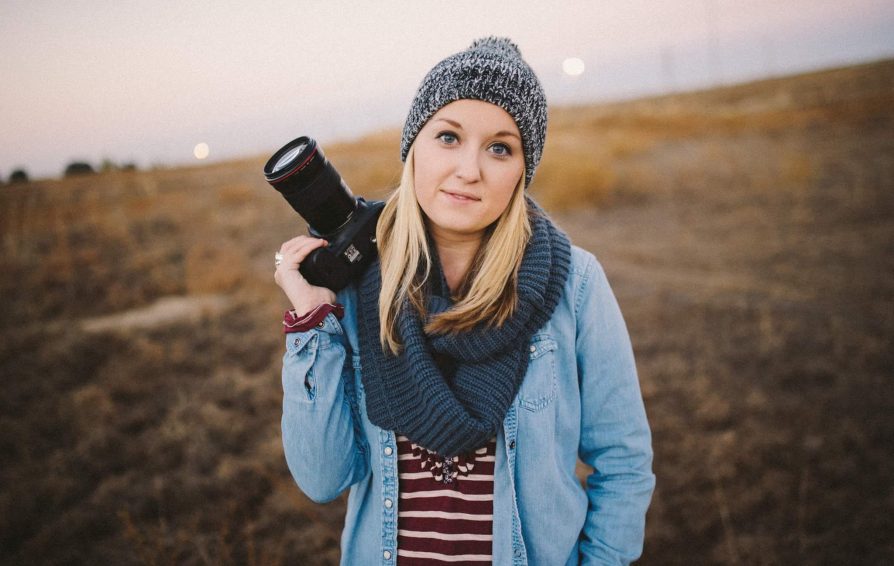 photographer holding her camera in a field