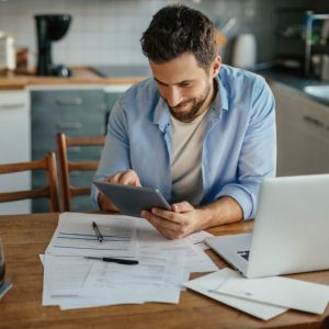 Man tracking invoice payments at his desk