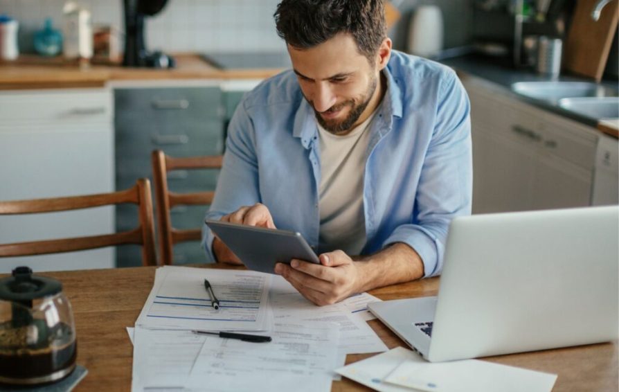 Man tracking invoice payments at his desk
