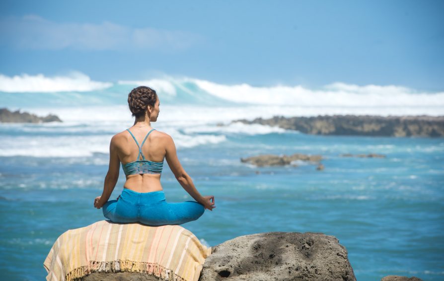 person practicing meditation while looking at the ocean