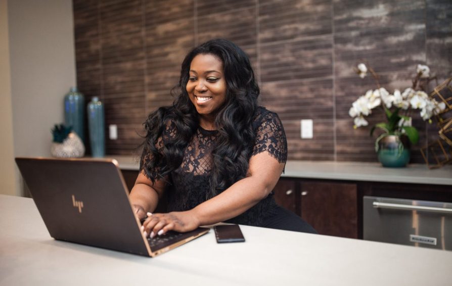 a woman smiling at a laptop learning how to make funnel ads that work