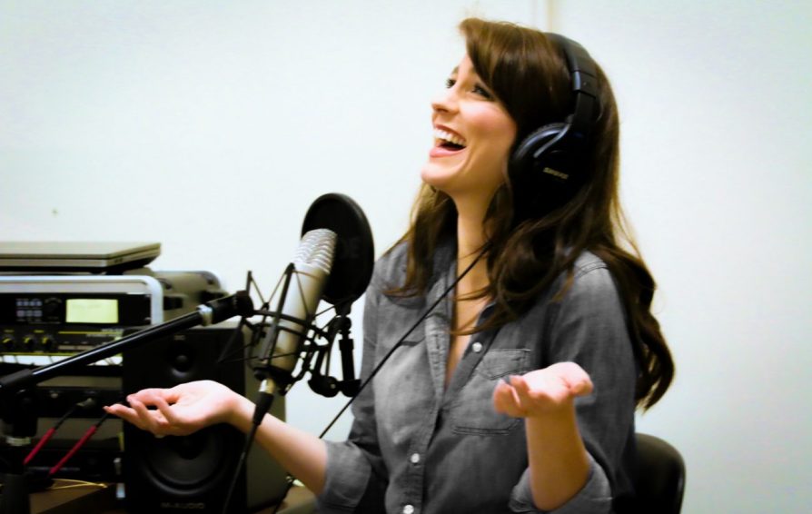 woman with headphones in front of a microphone