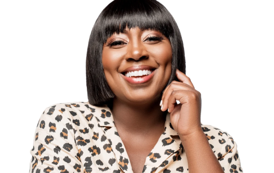 A headshot of a woman smiling. She has a bob haircut and wears a leopard print shirt.