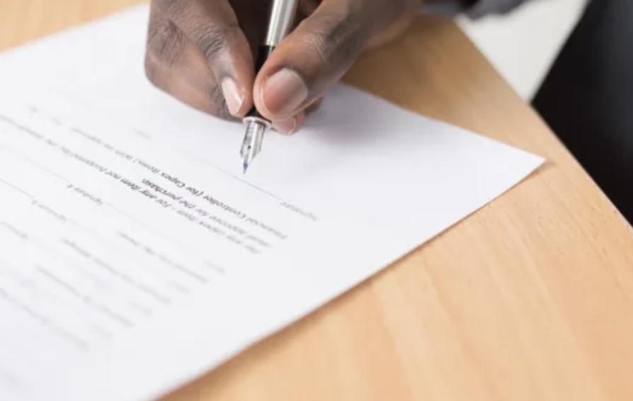 a man with a pen about to sign a copyright protection contract
