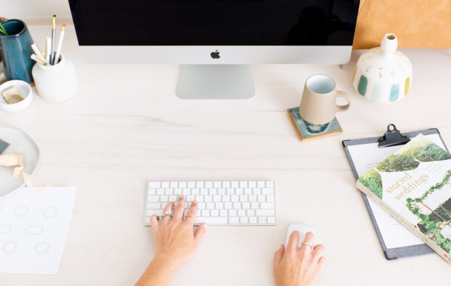 Woman with hands on keyboard and mouse.