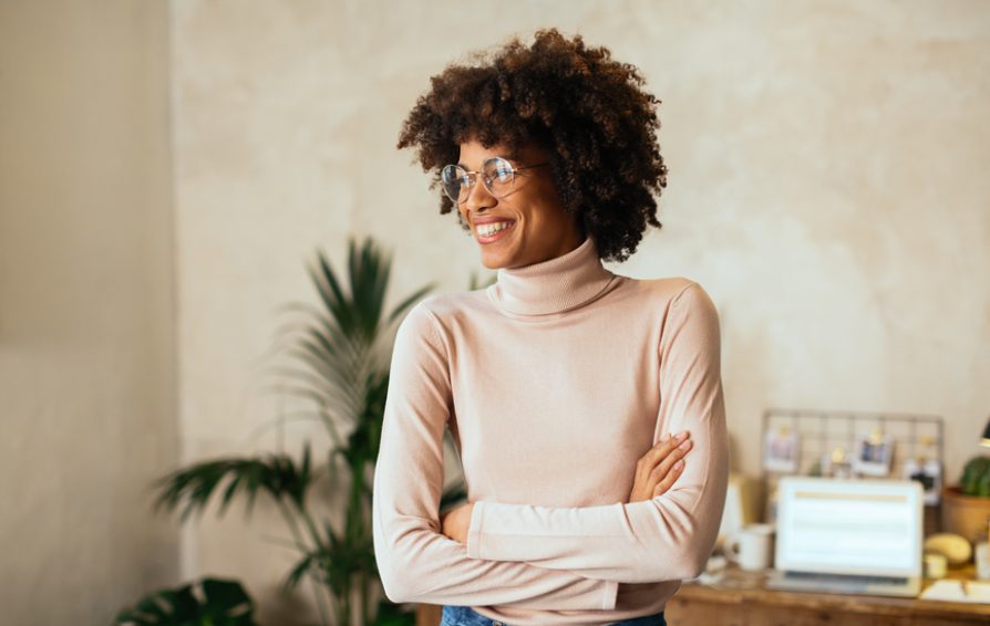 a woman smiling and learning how to create a podcast
