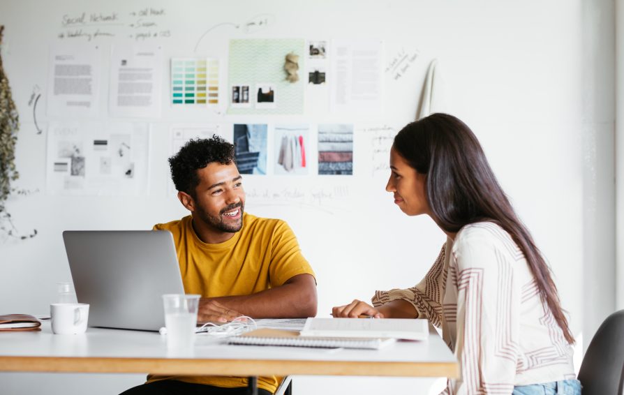 A man and woman work together at a table.