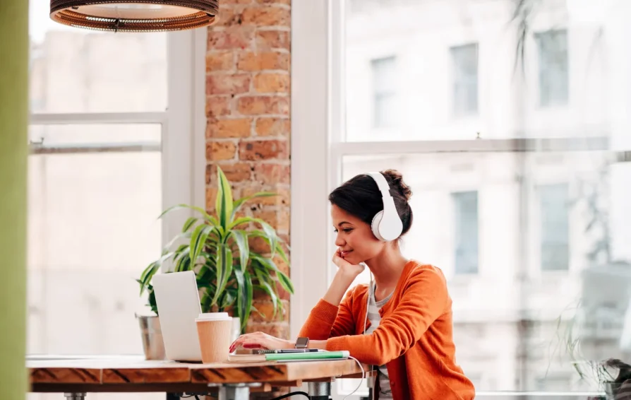 A woman sitting at a table working on her computer