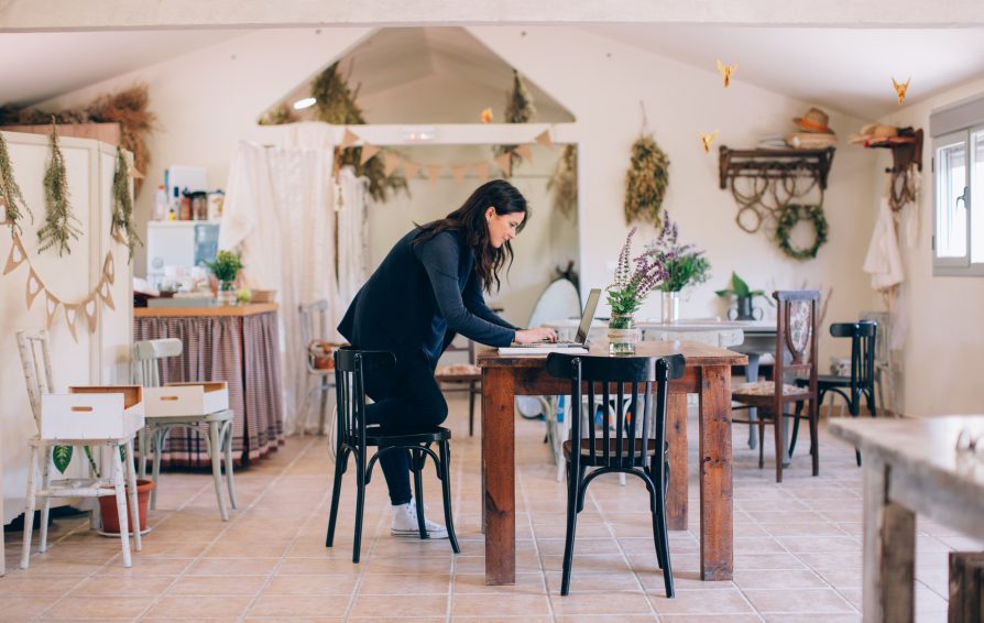 Brunette woman working with the laptop in her eco farm.