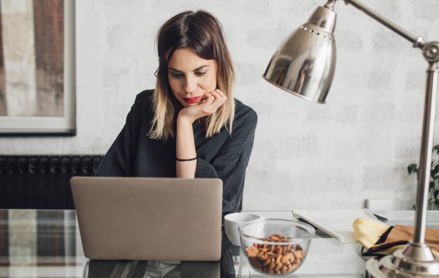 woman looking at her computer doing bookkeeping
