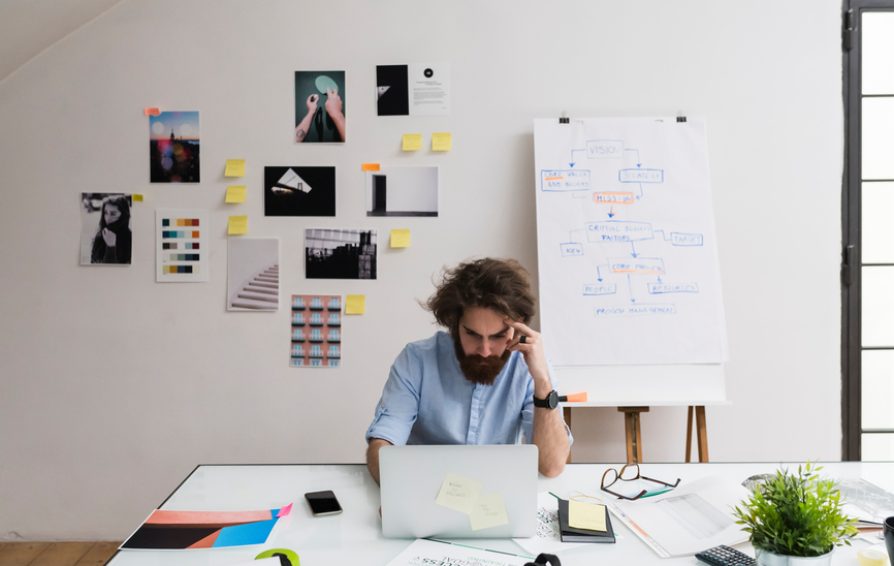 a man at a desk working to forecast his business year for success