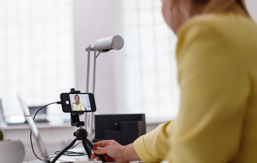 Podcaster prepping the camera and mic to record a podcast