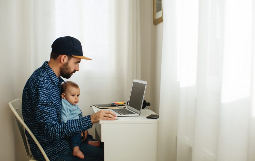 a freelancer at a laptop with a baby on his lap learning how to plan rest