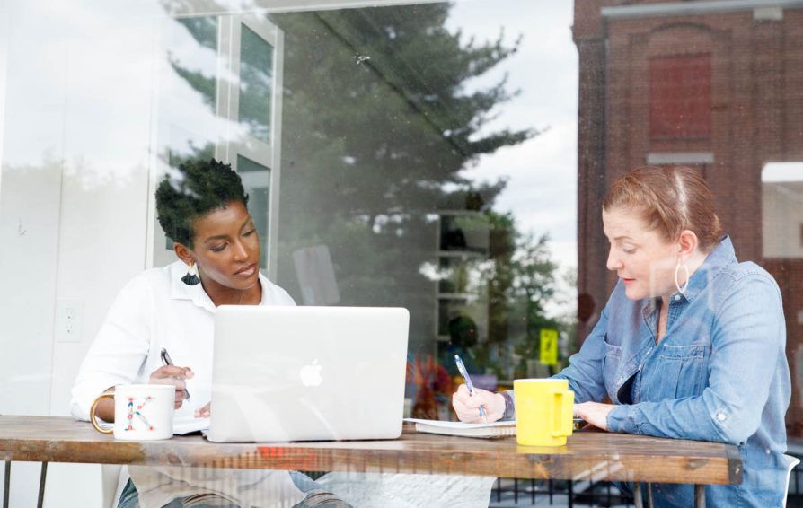 two people working on their schedule in a coffee shop