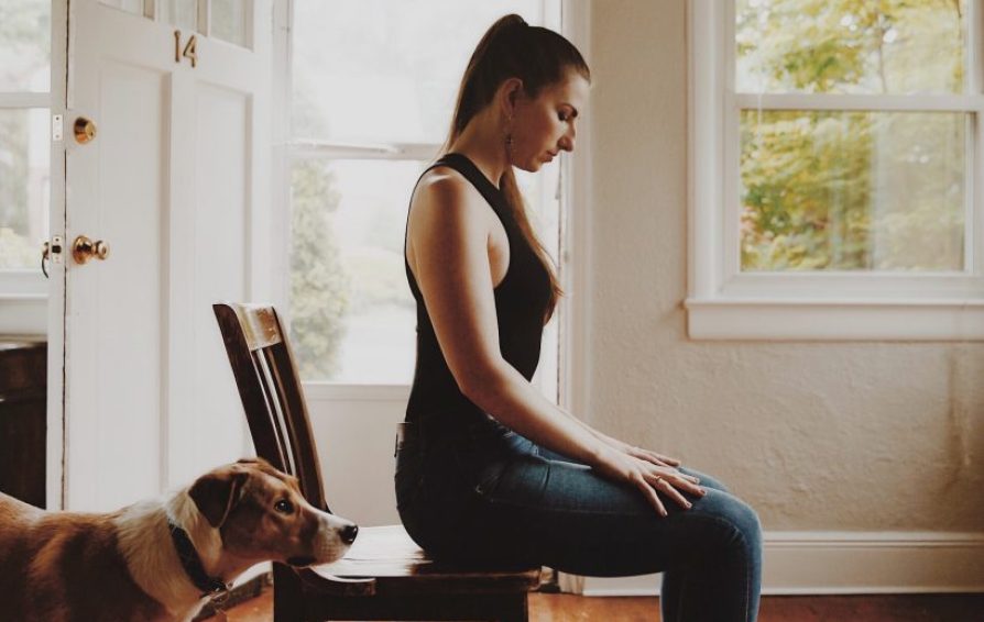 a woman seated in a chair concentrating on developing resilience