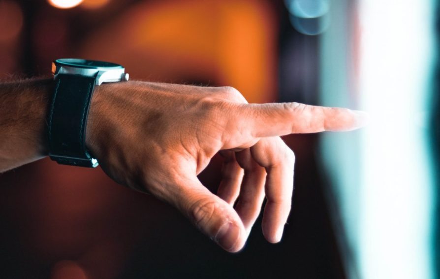 a hand with a wristwatch pointing to a light area