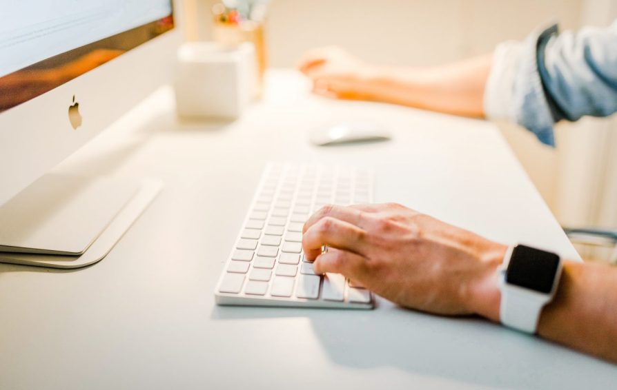 Close up of hands using a keyboard and mouse.