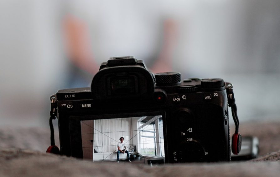 A DSLR camera sits in focus with the subject out of focus in the background