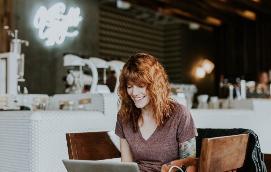 smiling woman on her laptop learning about email signature best practices